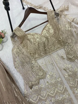 Elegant woman in a beige embroidered georgette short kurta sharara suit set with a matching net dupatta - Elegant Golden Sequin Indian Ethnic Wear for Weddings and Festivals