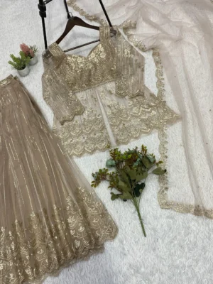 Elegant woman in a beige embroidered georgette short kurta sharara suit set with a matching net dupatta - Elegant Golden Sequin Indian Ethnic Wear for Weddings and Festivals