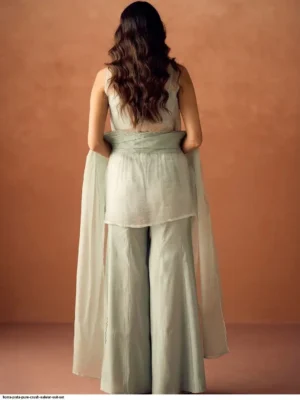 Model wearing a FIORRA sea green crush organza sleeveless straight kurta featuring delicate hand work and floral lace detailing at the hem, paired with matching wide-leg palazzo pants and an organza dupatta - Women Sea Green Crush Organza Hand Work Straight Kurta Set with Dupatta