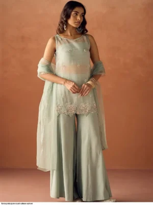 Model wearing a FIORRA sea green crush organza sleeveless straight kurta featuring delicate hand work and floral lace detailing at the hem, paired with matching wide-leg palazzo pants and an organza dupatta - Women Sea Green Crush Organza Hand Work Straight Kurta Set with Dupatta
