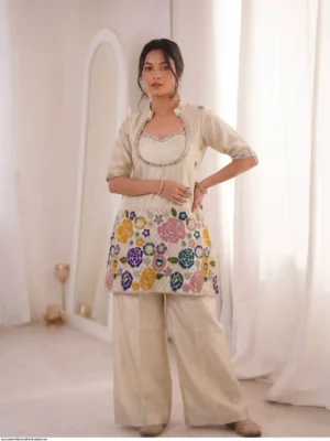 ivory cream tissue shimmer silk ethnic co-ord set featuring a short kurta with an embroidered sweetheart bustier panel, real mirror work along the neckline, and a heavy multicolored floral sequin border, paired with loose matching palazzo pants