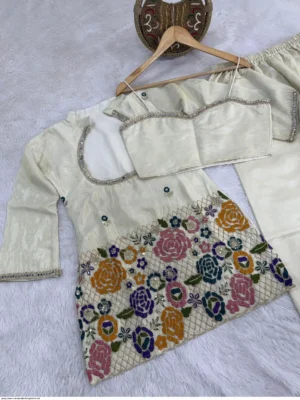 vory cream tissue shimmer silk ethnic co-ord set featuring a short kurta with an embroidered sweetheart bustier panel, real mirror work along the neckline, and a heavy multicolored floral sequin border, paired with loose matching palazzo pants